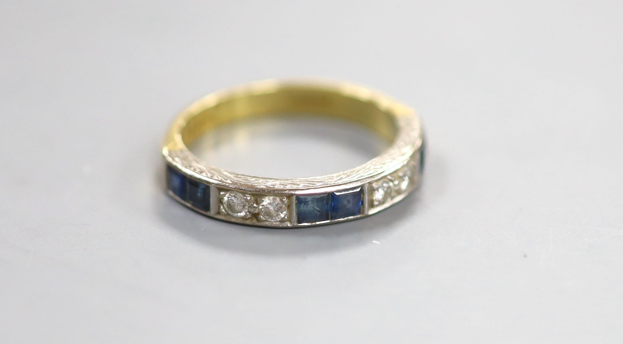 A modern 18ct gold and channel set six stone sapphire and four stone diamond half hoop ring, size O, gross 4.8 grams.